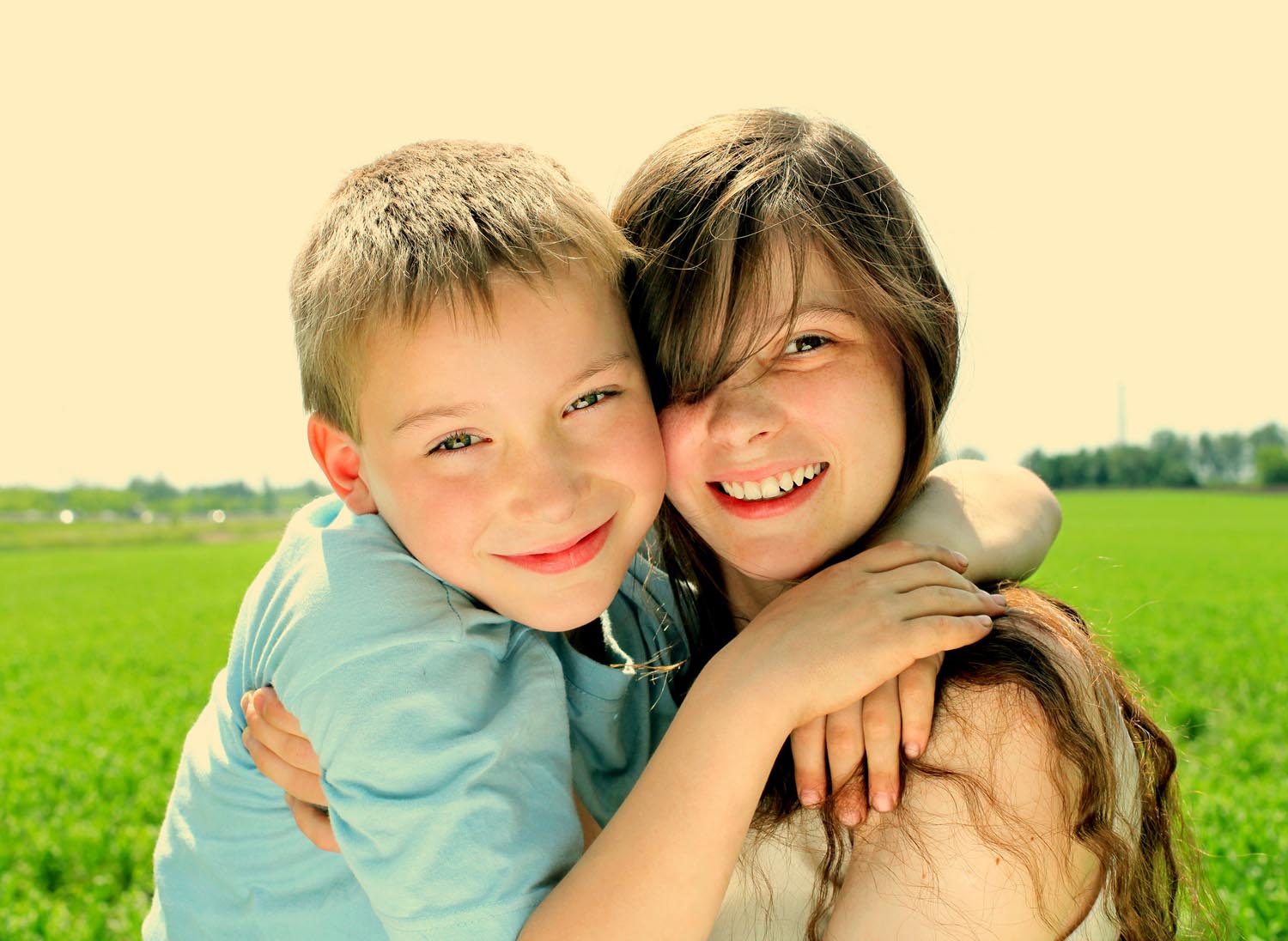 Two young children smiling and hugging each other