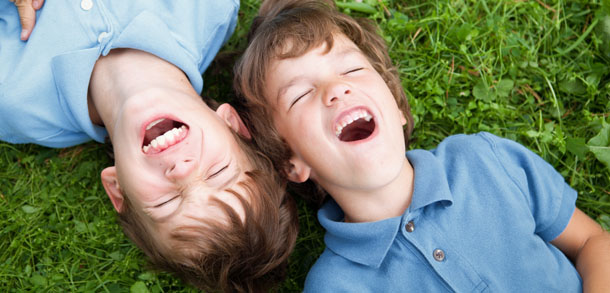 Brothers lying on grass, laughing