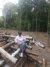 Deborah sat on a log in a forest