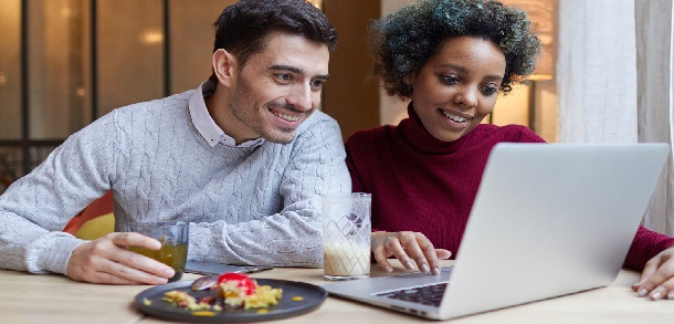 young, mixed race couple looking at a laptop screen