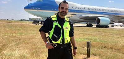 stuart standing in front of a plane in police uniform