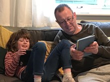 Barry and Martha playing with tablets on the sofa