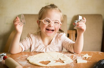 A young girl with disabilities baking cookies 